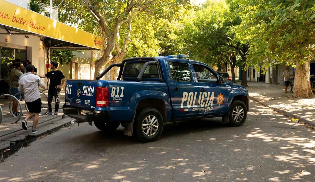 Sebuah truk polisi memblokir jalan di luar supermarket Unico, jaringan toko kelontong milik mertua pemain sepak bola Lionel Messi, setelah ditembak di Rosario, Argentina, 2 Maret 2023. Dilaporkan ada 14 tembakan yang mengenai bagian depan toko tersebut. (AP Photo/Sebastian Lopez Brach)