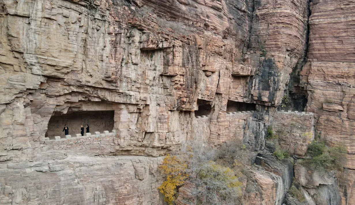 Foto dari udara pada 28 Oktober 2020 ini menunjukkan wisatawan menyusuri jalur di tebing dekat Waduk Xiagou yang berada di Chaiguan, Kota Shahe, Provinsi Hebei, China utara. Jalur tebing pada dinding Waduk Xiagou ini digali secara manual pada 1970-an. (Xinhua/Mu Yu)