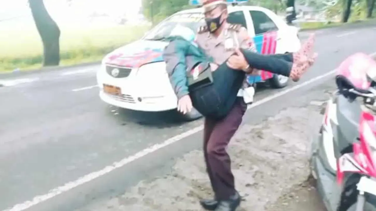 Polisi bopong ibu hamil yang jatuh saat kendarai motor di Sragen. (Foto: Istimewa/Solopos)