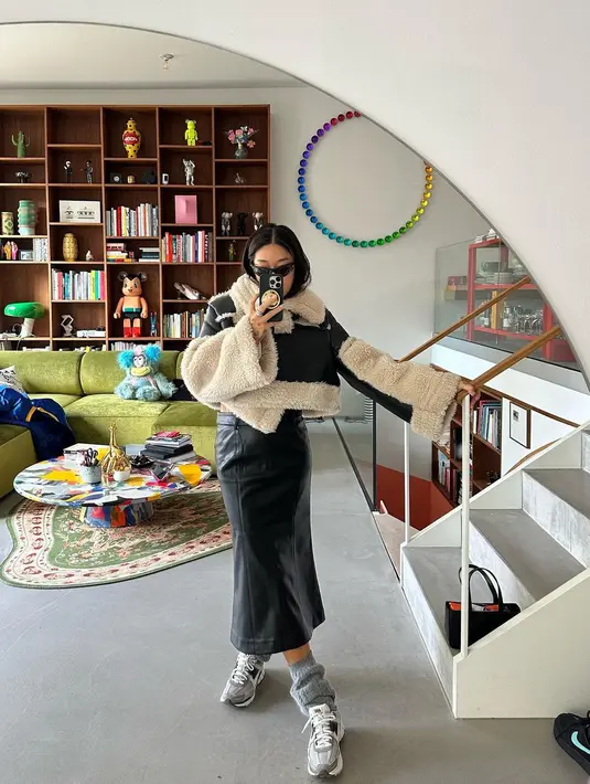 Peggy Gou dengan jaket berbulu 2 warna, dipadunya dengan rok kulit hitam. Padu padannya semakin keren dengan sneakers dan kaus kaki panjang abu-abu, serta sunglasses. [Foto: Instagram/peggygou_]