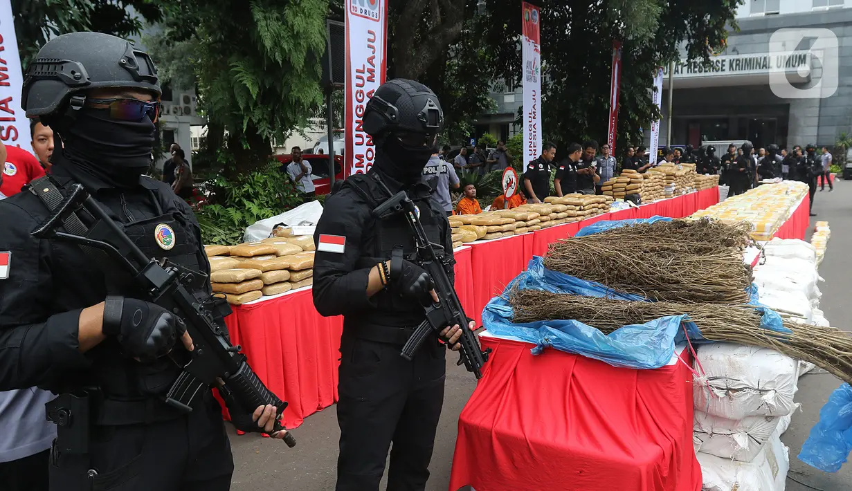Polisi bersenjata berjaga dekat barang bukti saat rilis pemusnahan narkoba di Mapolda Metro Jaya, Rabu (19/2/2020). Barang bukti tersebut merupakan hasil temuan dijajaran Polres selama bulan Januari 2020 seperti sabu, ganja, esktasi, heroin, happy five dan gorilla. (Liputan6.com/Herman Zakharia)