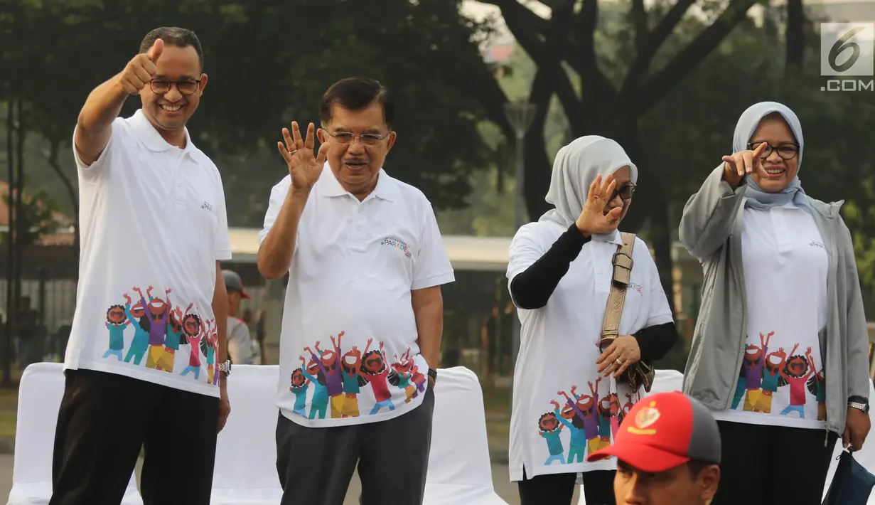 Wakil Presiden Jusuf Kalla didampingi Gubernur DKI Anies Baswedan melambaikan tangan saat melepas parade Asian Games 2018 di Monas, Jakarta, Minggu (13/5). Parade Asian Games 2018 digelar di dua kota, Jakarta dan Palembang. (Liputan6.com/Arya Manggala)