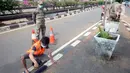 Petugas Satpol PP memberikan sanksi sosial mengcat pembatas jalan kepada warga pelanggar karena tidak menggunakan masker di Lebak Bulus, Jakarta, senin (14/09/2020). Pemerintah Provinsi DKI Jakarta memperketat kembali PSBB karena kasus Covid-19 terus mengalami peningkatan. (merdeka.com/Dwi Narwoko)