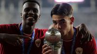 Selebrasi pemain Timnas Indonesia U-19, Jens Raven (kanan) bersama Meshaal Hamzah dengan mencium trofi juara Piala AFF U-19 2024 usai mengalahkan Thailand U-19 pada laga final di Stadion Gelora Bung Tomo, Surabaya, Senin (29/7/2024). (Bola.com/Bagaskara Lazuardi)