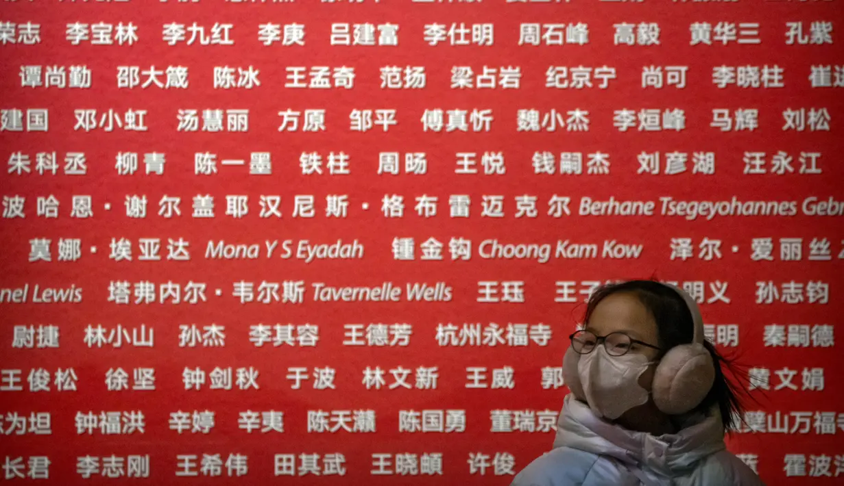 Seorang gadis mengenakan masker berjalan melalui lobi Museum Seni Nasional China di Beijing, Rabu (1/2/2023). Pengunjung terus berduyun-duyun ke museum, situs bersejarah, dan tempat wisata di ibu kota China saat periode liburan Tahun Baru Imlek berakhir. (AP Photo/Mark Schiefelbein)