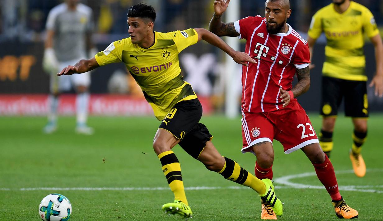 Gelandang Dortmund, Mahmoud Dahoud, melewat gelandang Bayern Munchen, Arturo Vidal, pada laga Piala Super Jerman di Stadion Signal Iduna Park, Dortmund, Sabtu (5/8/2017). Bayern Munchen menang adu penalti 5-4 atas Dortmund. (AFP/Patrik Stollarz)