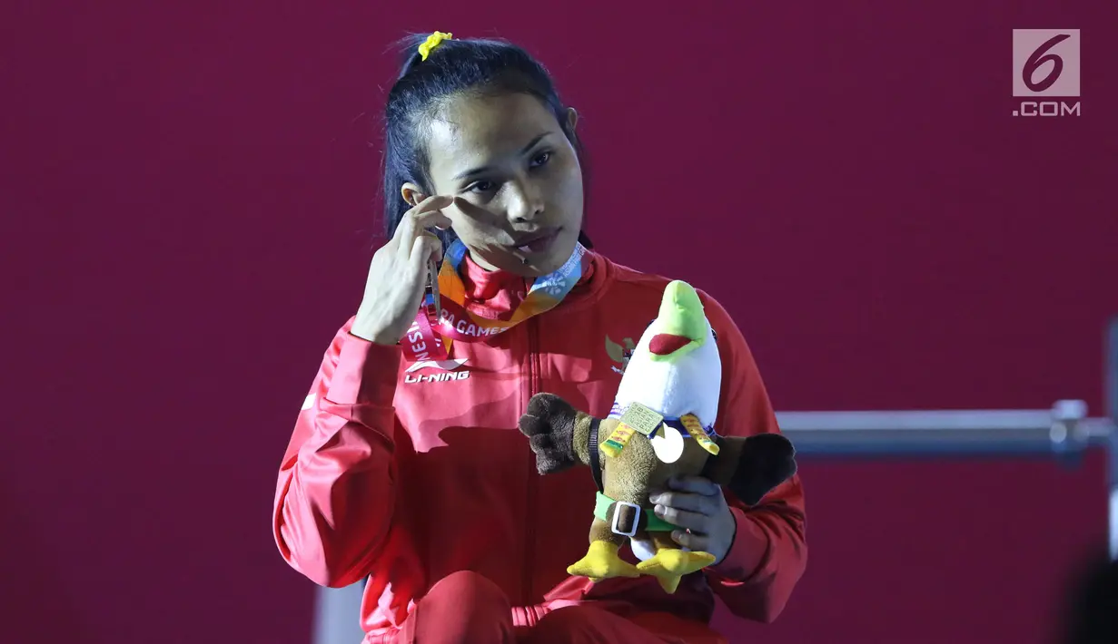 Atlet Para Powerlifting Indonesia, Ni Nengah Widiasih saat prosesi medali Womens Up to 41.00kg Asian Para Games 2018 di Jakarta, Minggu (7/10). Ni Nengah meraih perak perdana untuk Indonesia di Asian Para Games 2018. (Liputan6.com/Helmi Fithriansyah)
