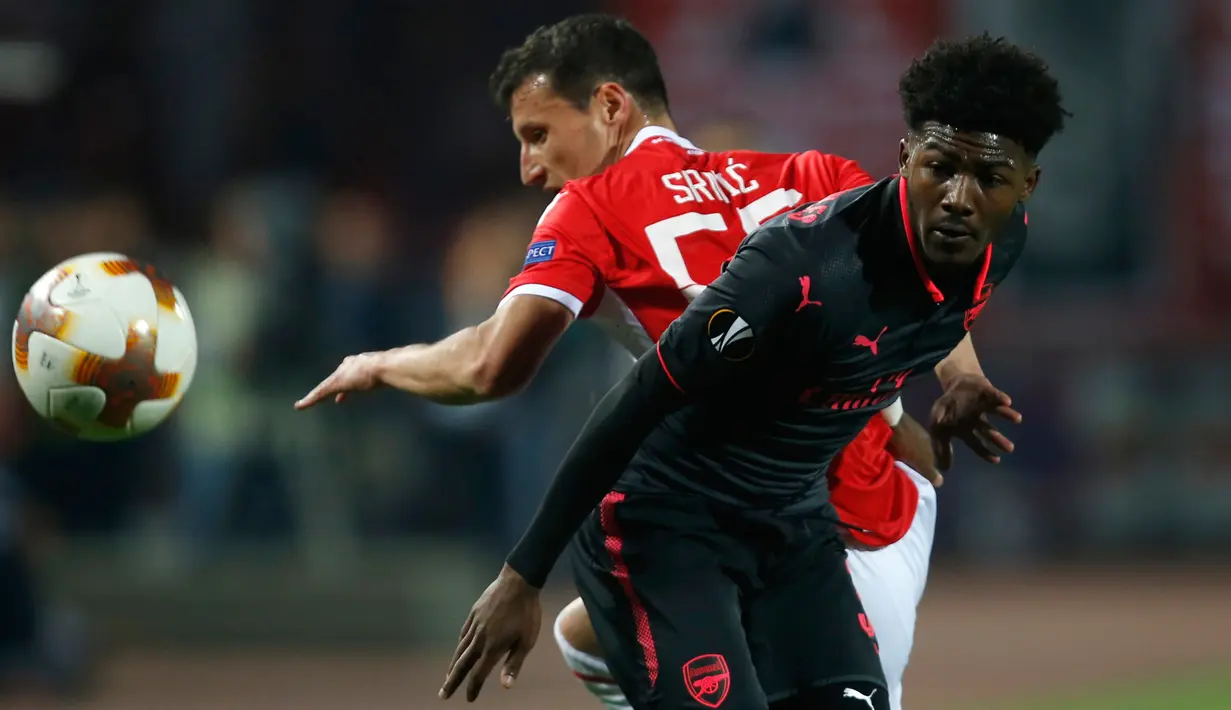 Pemain Arsenal, Ainsley Maitland-Niles berebut bola dengan pemain Red Star Belgrade, Slavoljub Srnic pada pertandingan Grup H Liga Europa di Stadion Rajko Mitic, Kamis (19/10). Arsenal menang 1-0, berkat gol Olivier Giroud. (AP/Darko Vojinovic)