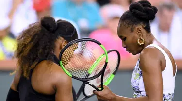 Venus Williams (kanan) saat pertandingan melawan adiknya Serena Williams dalam turnamen BNP Paribas Open di Indian Wells Tennis Garden, California (12/3). (Harry How / Getty Images / AFP)