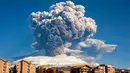 Asap mengepul dari Gunung Etna di Catania, Sisilia, Italia, Selasa (16/2/2021). Gunung Etna menumpahkan lahar panas dan abu vulkanik. (Davide Anastasi/LaPresse via AP)