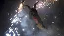 Seorang warga berpakaian seperti hantu dengan memegang tongkat kembang api selama perayaan " Correfocs ", Mallorca, Spanyol, (24/1). Ini merupakan perayaan tradisional yang menandai menandai akhir dari perayaan lokal di Palma. (REUTERS / Enrique Calvo)