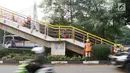 Pekerja mengecat jembatan penyeberangan orang (JPO) di kawasan Cipayung, Jakarta Timur, Rabu (30/5). Pengecatan dilakukan untuk merawat JPO agar tidak kusam dan lebih nyaman digunakan oleh pejalan kaki. (Liputan6.com/Immanuel Antonius)