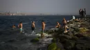 <p>Orang-orang mendinginkan diri pada musim panas yang terik di Bosphorus, Istanbul, Turki, 13 Juli 2023. (AP Photo/Francisco Seco)</p>