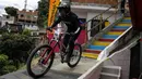 Pebalap sepeda Chili, Pedro Ferrerira memacu sepedanya pada ajang MTB Red Bull Medellín Cerro Abajo Urban Downhill, di perkampungan padat penduduk "La comuna 13", Medellin, Kolombia, pada 4 Maret 2023. (AFP/Freddy Builes)