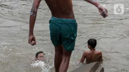 Anak-anak berenang di Sungai Ciliwung, Jakarta, Selasa (24/8/2021). Sungai Ciliwung menjadi tempat alternatif untuk bermain di kala pandemi karena ditutupnya ruang-ruang bermain atau taman kota, dan juga karena kurangnya ruang bermain bagi anak-anak. (Liputan6.com/Johan Tallo)
