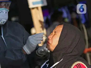 Petugas medis melakukan tes swab kepada pengguna KRL Commuter Line dengan metode polymerase chain reaction (PCR) di Stasiun Bekasi, Selasa, (5/5/2020). Pemkot Bekasi melakukan tes swab secara massal setelah tiga penumpang KRL dari Bogor terdeteksi terpapar virus corona (Liputan6.com/Herman Zakharia)