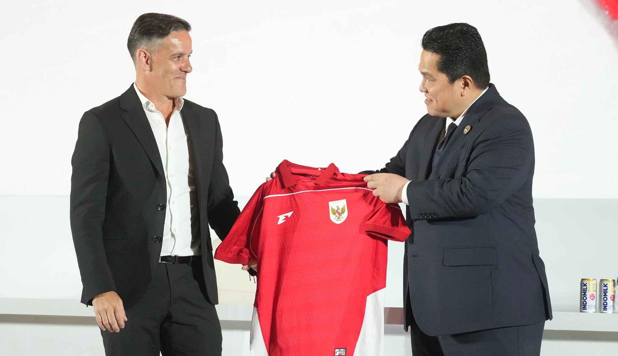 Ketua Persatuan Sepak Bola Seluruh Indonesia (PSSI), Erick Thohir (kanan) menyerahkan jersey tim kepada pelatih kepala tim nasional Indonesia yang baru ditunjuk, John Herdman, saat konferensi pers di Jakarta, Selasa 13 Januari 2026. Persatuan Sepak Bola Seluruh Indonesia (PSSI) resmi memperkenalkan John Herdman sebagai pelatih baru Timnas Indonesia. (AP Photo/Achmad Ibrahim)
