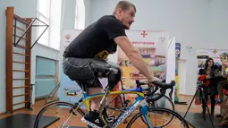 Seorang prajurit mengayuh sepeda dengan kaki palsunya saat mengikuti tes untuk turnamen Invictus Games Ukraine di Kiev, Ukraina (28/1). Dalam tes tersebut diikuti oleh 76 prajurit. (AP Photo/Efrem Lukatsky)