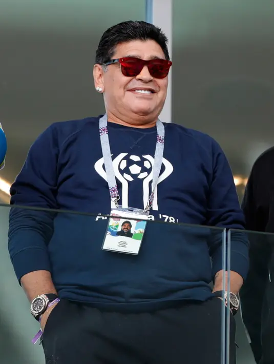 Senyum mantan bintang sepak bola, Diego Maradona saat menyaksikan laga antara Argentina dan Islandia dalam penyisihan Grup D Piala Dunia 2018 di Stadion Spartak, Moskow, Rusia, Sabtu (16/6). (AP Photo/Ricardo Mazalan)