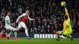Kiper Bournemouth Artur Boruc gagal menghalau bola dari pemain Arsenal, Mesut Ozil yang menjebol gawangnya pada laga lanjutan Liga Inggris, 2018-19 pekan ke-28 di Emirates Stadium, Rabu (27/2). Arsenal menang dengan skor telak 5-1. (Ian KINGTON/AFP)