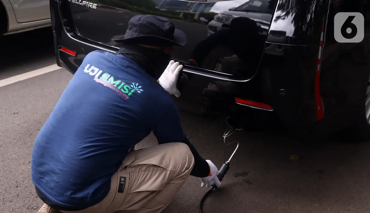 Petugas memeriksa emisi mobil di Jakarta Barat, Rabu (13/1/2021). Dinas Lingkungan Hidup DKI Jakarta mengumumkan kendaraan yang tidak mengikuti uji emisi atau tidak lulus uji emisi gas buang akan dikenakan disinsentif tarif parkir yang tinggi dan tilang. (Liputan6.com/Angga Yuniar)