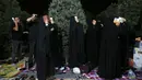 Umat Syiah Iran mengenakan pakaian berwarna hitam menempatkan salinan Al Quran diatas kepala mereka saat berdoa pada malam Ramadan di Teheran, Iran (16/6). Mereka membaca Al Quran dan berdoa untuk meminta pengampuan. (AP Photo/Vahid Salemi)