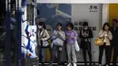 Orang-orang menunggu trem di Hong Kong  (1/3/2023). Pencabutan penggunaan masker sebagai salah satu upaya Hong Kong untuk menarik dan menyambut wisatawan dan pembisnis pasca aturan ketat hampir selama tiga tahun. (AFP/Isaac Lawrence)