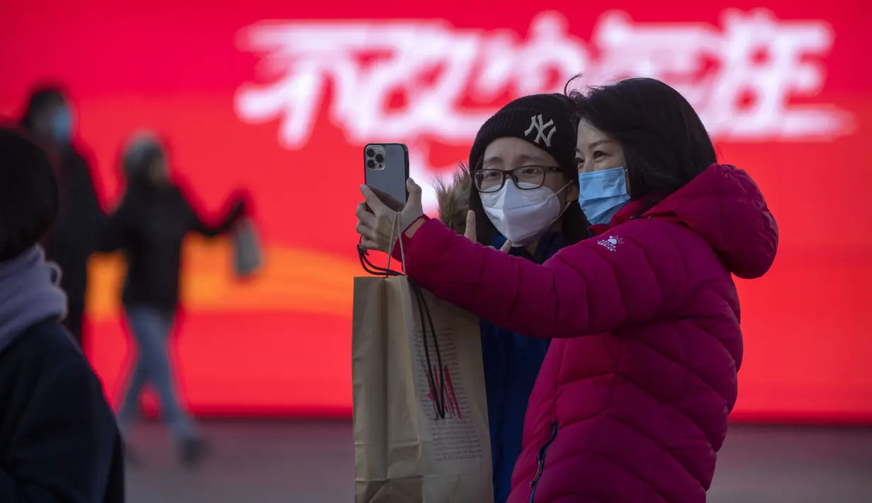 Pengunjung yang mengenakan masker berfoto selfie di pusat perbelanjaan kelas atas pada hari terakhir pekan liburan Tahun Baru Imlek di Beijing, Jumat, 27 Januari 2023. (AP Photo/Mark Schiefelbein)