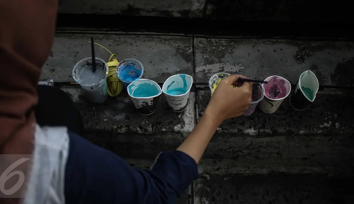 Pengunjung memilih cat warna untuk melukis di kanvas saat kegiatan Car Free Day (CFD) di kawasan Bundaran HI, Jakarta, Minggu (12/2). Aksi yang digelar oleh Greenpeace itu untuk mengenalkan masyarakat tentang sadar polusi. (Liputan6.com/Faizal Fanani)