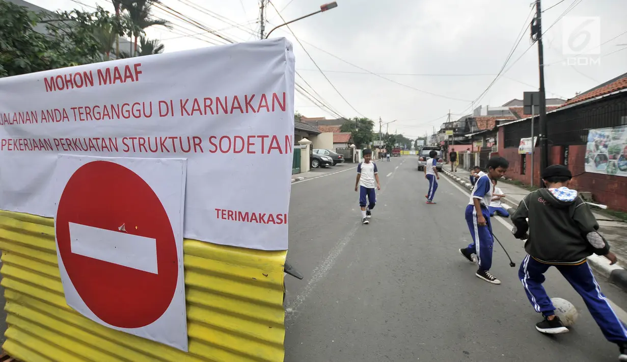 Anak-anak bermain bola saat penutupan Jalan Otista III, Jakarta, Selasa (4/12). Penutupan Jalan Otista III untuk memperlancar pengerjaan konstruksi dan penguatan terowongan pengendali banjir sodetan Kali Ciliwung. (Merdeka.com/Iqbal Nugroho)