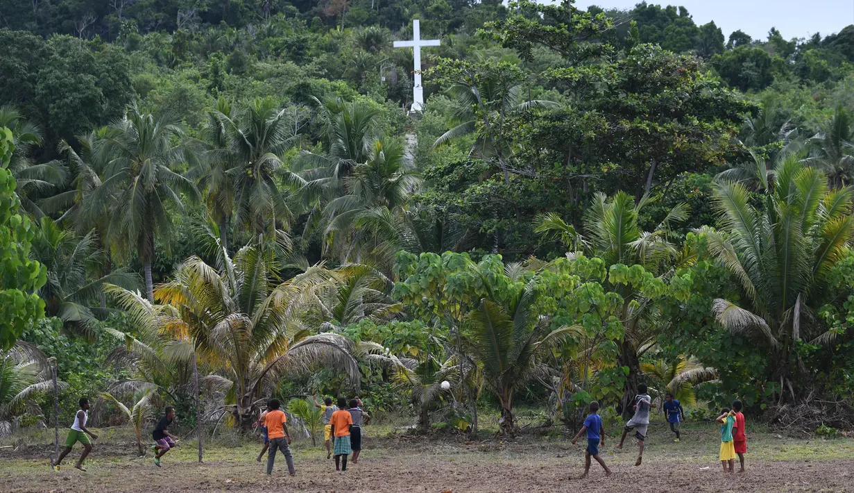 Sejumlah anak dari suku Byak Betew bermain sepak bola setelah misa hari Minggu di pulau Saukabu, satu dari 1.500 pulau di Raja Ampat 20 Agustus 2017. Raja Ampat  yang berarti Empat Raja terdiri dari 1.500 pulau. (AFP Photo/Goh Chai Hin)