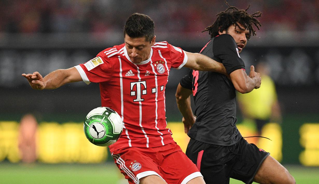 Striker Bayern Munchen, Robert Lewandowski, berebut bola dengan gelandang Arsenal, Mohamed Elneny pada laga ICC 2017, di Stadion Shanghai, Rabu (19/7/2017). Arsenal menang adu penalti dengan skor 3-2 atas Bayern Munchen. (AFP/Johannes Eisele)