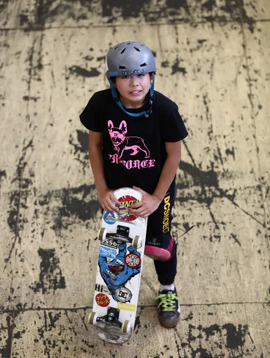 Skateboarder Misugu Okamoto berpose dengan membawa skateboard saat sesi latihan di Kota Ama, Prefektur Aichi, Jepang, 2 Juli 2019. Okamoto bertekad menjadi skateboarder yang dapat bersaing dengan para pemain terbaik dunia. (Behrouz Mehri/AFP)