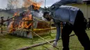 Polisi membakar tumpukan ganja sitaan saat upacara di Polda Aceh, Banda Aceh, Aceh, Rabu (23/9/2020). Sebanyak 372,6 kilogram ganja dan 80,2 kilogram sabu serta 27.400 pil ekstasi hasil sitaan polisi dimusnahkan dalam acara tersebut. (CHAIDEER MAHYUDDIN/AFP)
