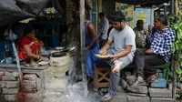 Orang-orang makan di warung pinggir jalan di Kolkata, India, Rabu (9/6/2021). India melonggarkan sebagian pembatasan untuk mengekang penyebaran virus corona COVID-19. (AP Photo/Bikas Das)