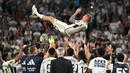 Pemain Real Madrid melemparkan Toni Kroos ke udara saat upacara perpisahan untuk sang pemain setelah laga Liga Spanyol 2023/2024 melawan Real Betis di Santiago Bernabeu, Madrid, Spanyol, Minggu (26/05/2024) dini hari WIB. Kroos memutuskan untuk pensiun dari sepak bola setelah Euro 2024 nanti. (AFP/Javier Soriano)