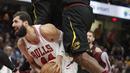 Pemain Chicago Bulls, Nikola Mirotic (bawah) berusaha memasukan bola saat dikepung dua pemain Cleveland Cavaliers pada laga NBA basketball game di Quicken Loans Arena, Cleveland, (21/12/2017). Cleveland menang 115-112.  (AP/Tony Dejak)
