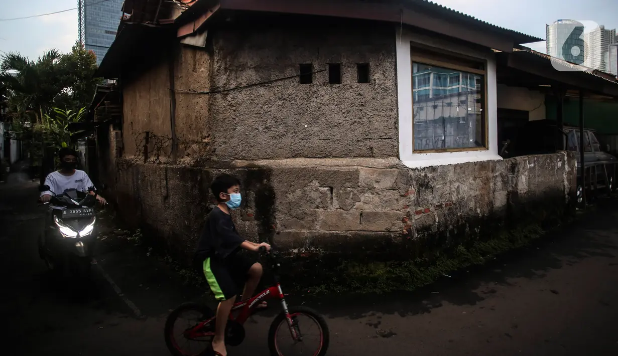 Seorang anak bermain sepeda di Perumahan Padat Penduduk kawasan Kuningan Jakarta, Kamis (1/7/2021). Kasus corona di Jakarta dalam beberapa hari terakhir terus melonjak tinggi. (Liputan6.com/Johan Tallo)