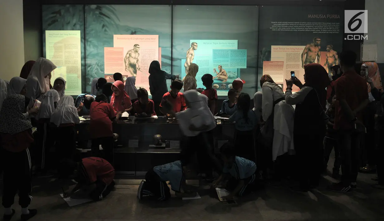 Rombongan siswa SD melihat informasi sejarah manusia purba di Museum Nasional, Jakarta, Selasa (26/6). Merayakan ulang tahun Jakarta ke-491, Pemprov DKI menggratiskan tiket masuk museum-museum yang berada di Jakarta. (Merdeka.com/ Iqbal S. Nugroho)
