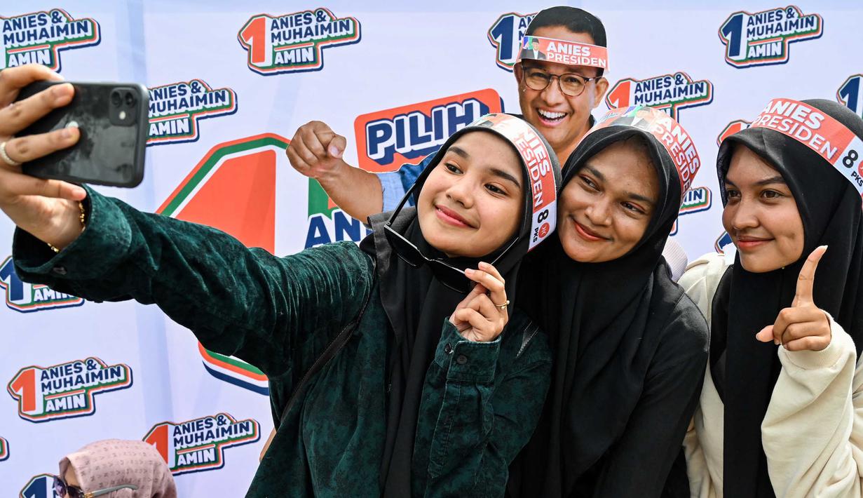 Pendukung Calon Presiden nomor urut 1, Anies Baswedan berswafoto saat mengikuti kampanye pemilu di Banda Aceh pada 27 Januari 2024. (CHAIDEER MAHYUDDIN/AFP)