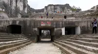 Wisatawan mengunjungi tempat rekreasi penambangan batu kapur di Bukit Jaddih, Bangkalan, Madura, Jawa Timur, Minggu (3/11/2019). Hingga saat ini tempat tersebut masih aktif sebagai lokasi penambangan batu kapur. (Liputan6.com/JohanTallo)