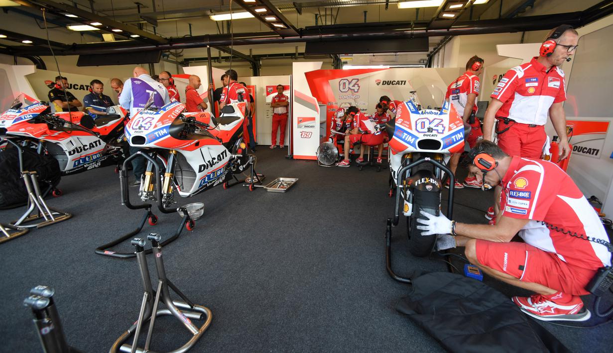 Mekanik sedang memeriksa motor pebalap Ducati, Andrea Dovizioso pada sesi latihan bebas balapan San Marino Moto GP Grand Prix di Marco Simoncelli Circuit, Misano (9/9/2017). (AFP/Andreas Solaro)