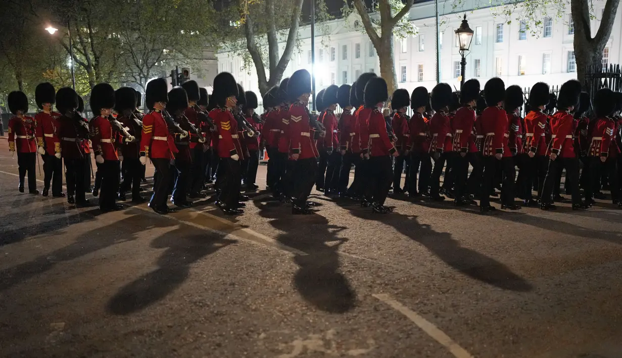 Anggota militer berbaris di dekat Istana Buckingham di pusat kota London, Selasa, 2 Mei 2023 saat latihan untuk penobatan Raja Charles III yang akan berlangsung di Westminster Abbey pada 6 Mei. (AP Photo/Andreea Alexandru)
