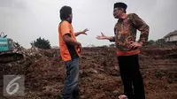 Wagub DKI Djarot berbincang dengan petugas saat meninjau pembangunan Waduk Rawa Minyak Pasar Minggu, Jakarta, Jumat (21/10). Djarot menyatakan akan menambah operator alat berat guna mempercepat pembangunan waduk. (Liputan6.com/Faizal Fanani)
