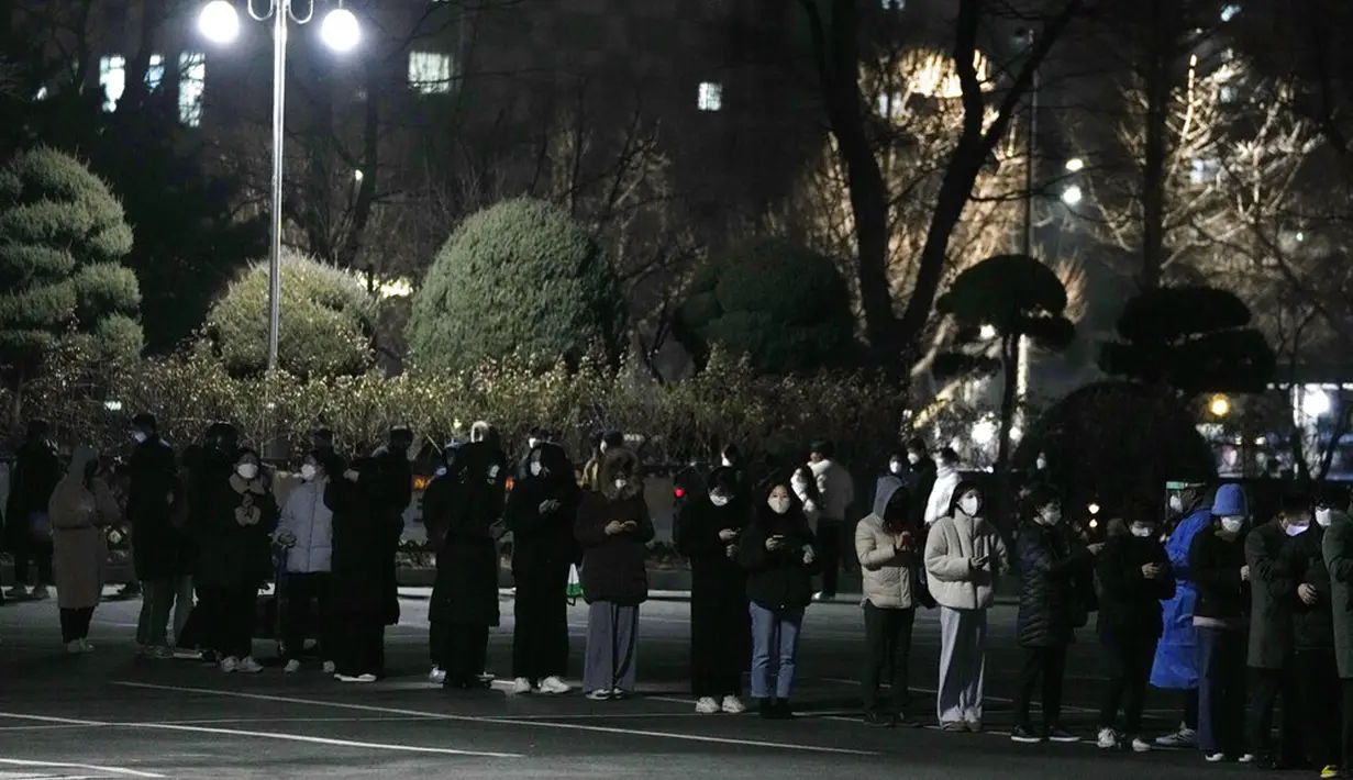 Orang-orang menunggu tes virus corona COVID-19 di tempat pengujian darurat, Seoul, Korea Selatan, Rabu (26/1/2022). Korea Selatan mulai memberlakukan aturan baru untuk merespons kasus COVID-19 baru yang melonjak hampir 50 persen dalam sehari. (AP Photo/Ahn Young-joon)