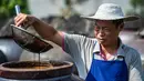 Seorang pekerja memeriksa kualitas cuka di Chishui, Provinsi Guizhou, China barat daya (26/6/2020). Chishui terkenal dengan cuka mataharinya, yang masih mempertahankan proses pembuatan secara tradisional. (Xinhua/Tao Liang)