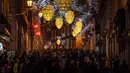 Orang-orang berjalan di bawah lampu Natal di Chiado di Lisbon (17/12). (AFP Photo/Patricia De Melo Moreira)