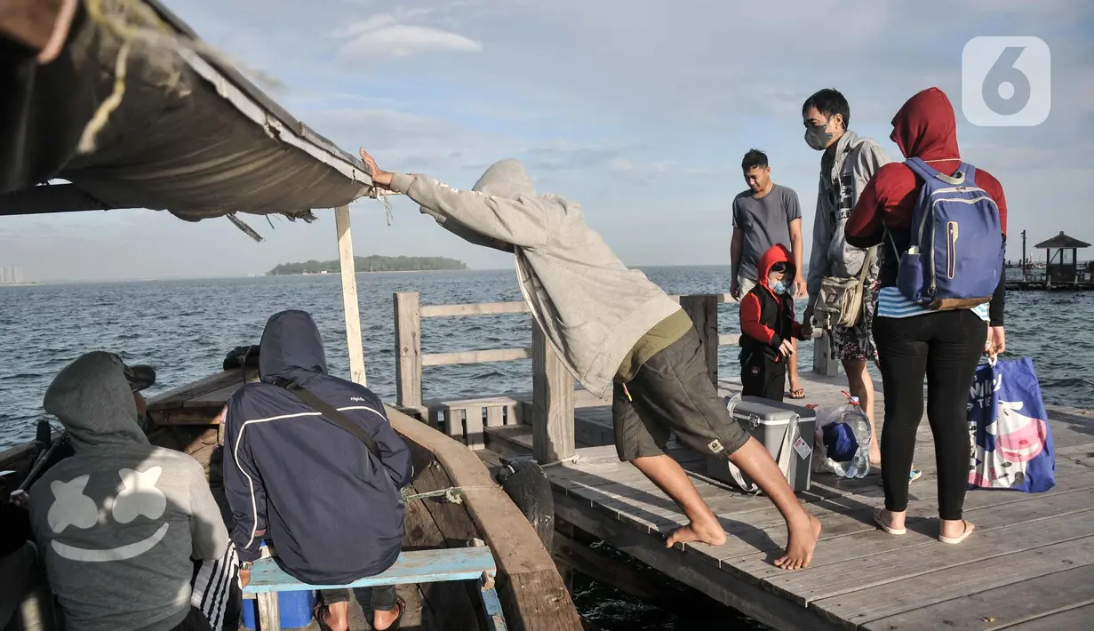 Nelayan saat menurunkan wisatawan di salah satu pulau di dermaga Kamal Muara, Jakarta, Minggu (27/2/2022). Destinasi Kepulauan Seribu masih menjadi tujuan wisata favorit warga Ibu Kota dalam mengisi liburan. (merdeka.com/Iqbal S. Nugroho)