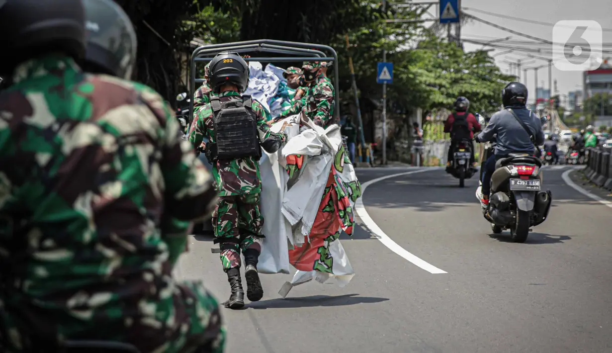Anggota TNI membawa baliho Rizieq Shihab usai mencopot paksa dari sekitar kawasan Petamburan, Jakarta, Jumat (20/11/2020). Pencopotan dilakukan karena menyalahi aturan yang telah ditetapkan. (Liputan6.com/Faizal Fanani)