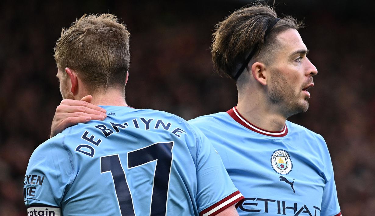 Pemain Manchester City, Kevin De Bruyne dan Jack Grealish melakukan selebrasi dalam pertandingan Liga Inggris 2022/2023 melawan Manchester United di Old Trafford, Sabtu (14/1/2023). Kemungkinan Kevin De Bruyne untuk membela Manchester City jika harus turun kasta sangatlah kecil. Apalagi De Bruyne masih ingin membawa Belgia berkibar di kancah Eropa dan dunia. (AFP/Oli Scarff)